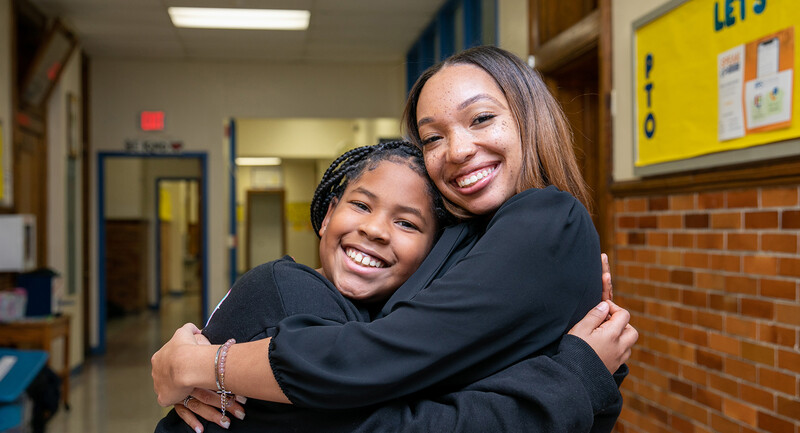 Barack Obama Elementary School Teacher of the Year Sharese Williams and one of her students share a joyful hug.